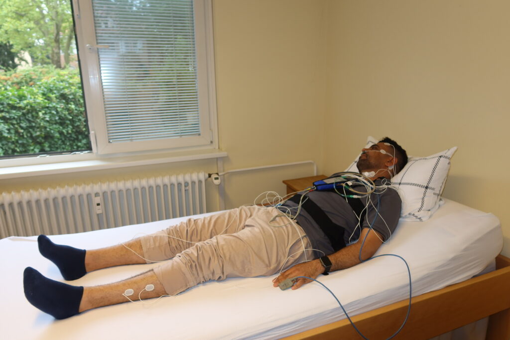 Patient bei einer schlafmedizinischen Messung auf der Untersuchungsliege der Praxis.